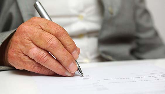 Older person's hand writing down health care directives
