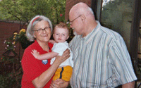 Photo of older couple holding infant